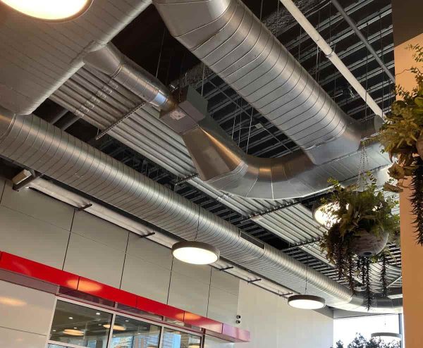 Technician installing ducted central air conditioning system