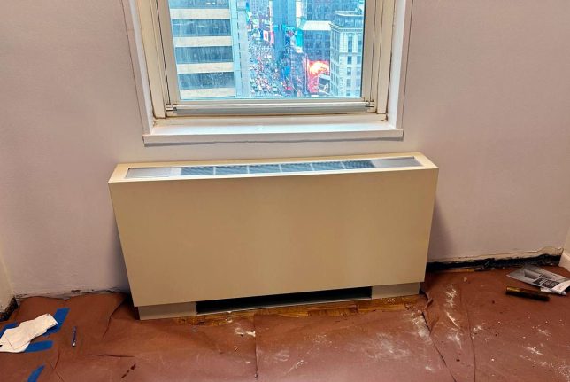 Technician installing fan coil unit in New York City