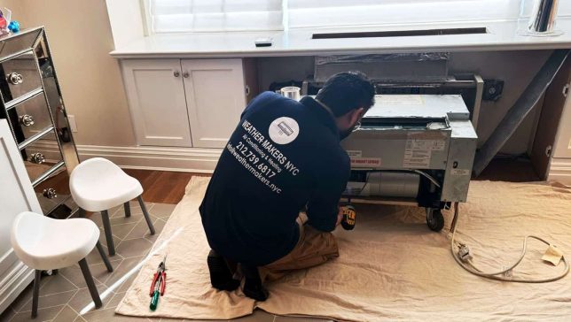 ptac-installation-nyc Technician installing PTAC unit in New York City